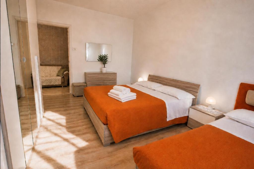 a bedroom with two beds and a living room at Home Istria 81 in Trieste