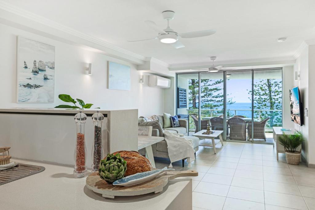 a kitchen and living room with a view of the ocean at Dwell @ 22, Oceanfront Apartment in Bargara