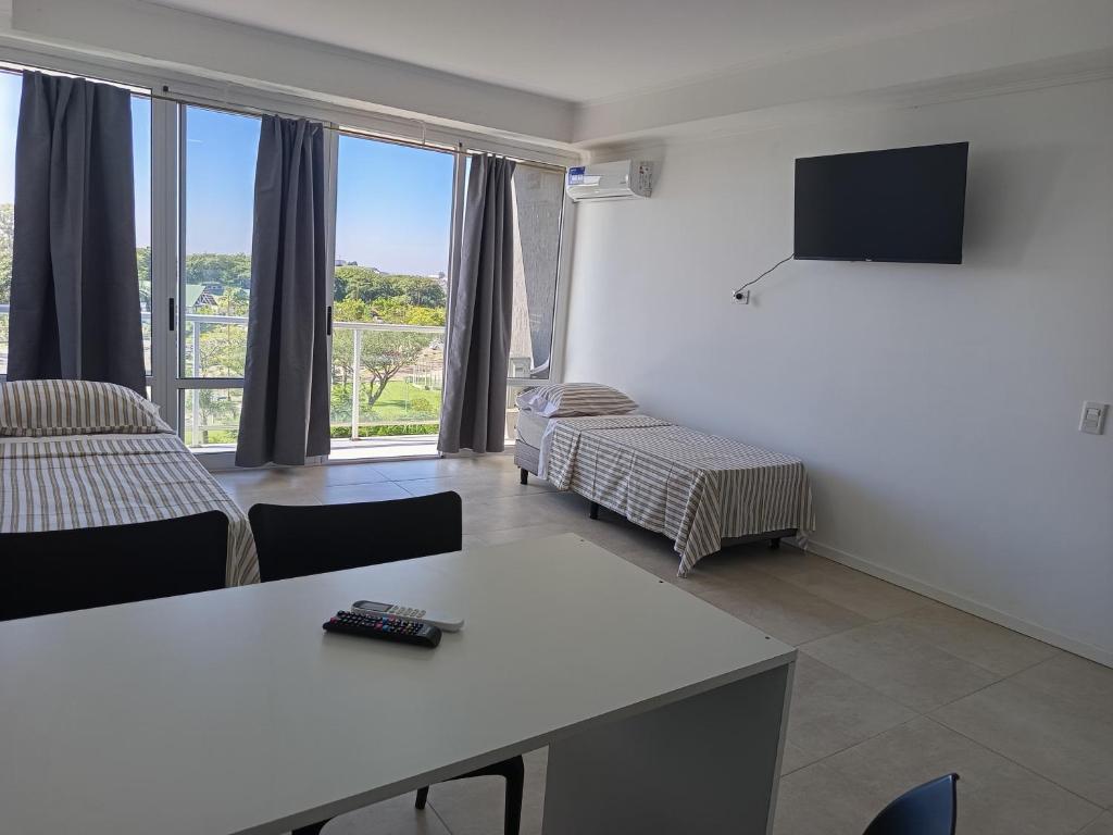 a room with a table and a bed and a television at Frente a Termas in Federación