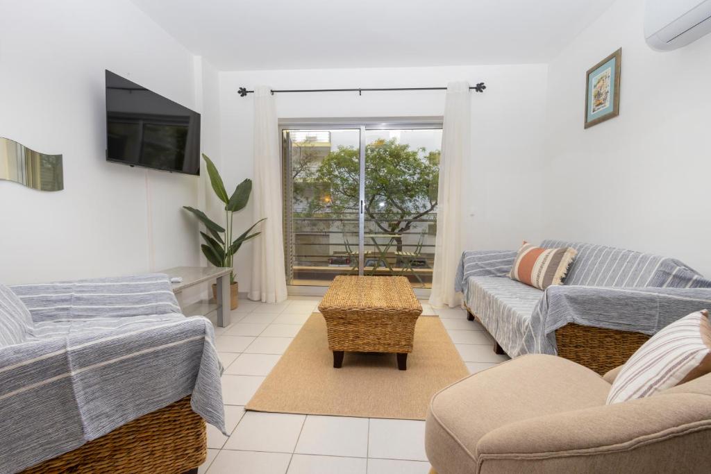 a living room with two couches and a tv at Cantinho Lusitano in Portimão