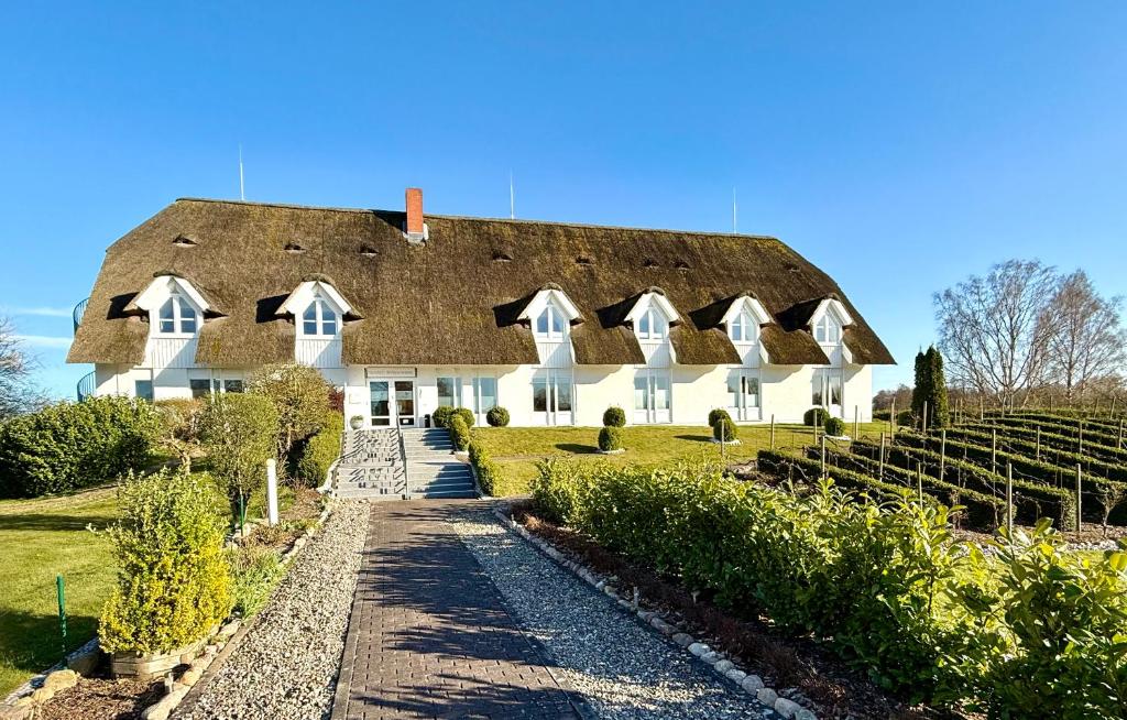 a large white house with a thatched roof at Alago Hotel am See in Cambs