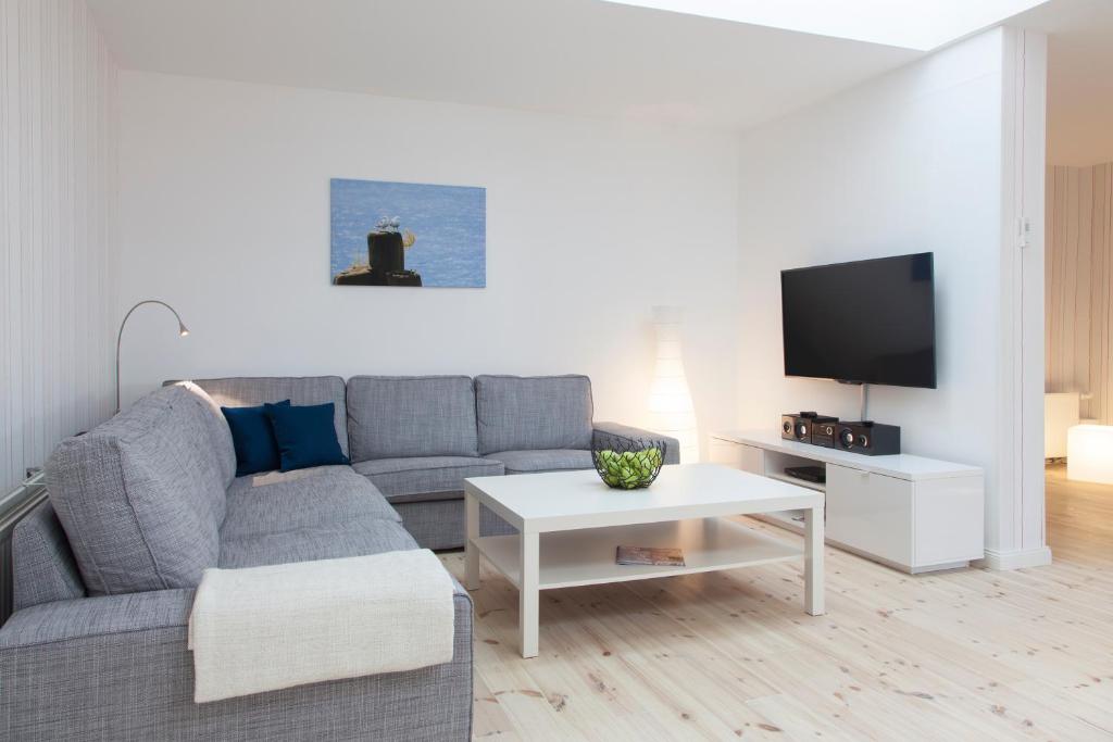 a living room with a gray couch and a white table at Dorotheenhof in Flensburg