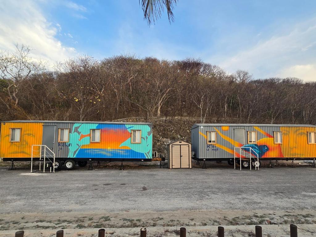 three trailers parked in a parking lot with graffiti at Casa en movimiento playabonita in Campeche