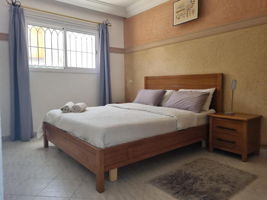 a bedroom with a large bed with a window and a bed sidx sidx sidx at Appartement Imi-Ouaddar 2 in Agadir nʼ Aït Sa