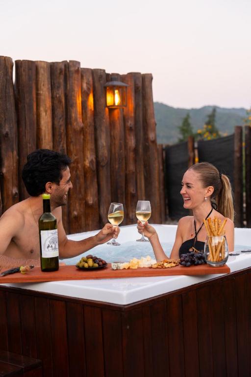 a man and woman sitting in a bath tub with wine glasses at La Cautiva in Lozano