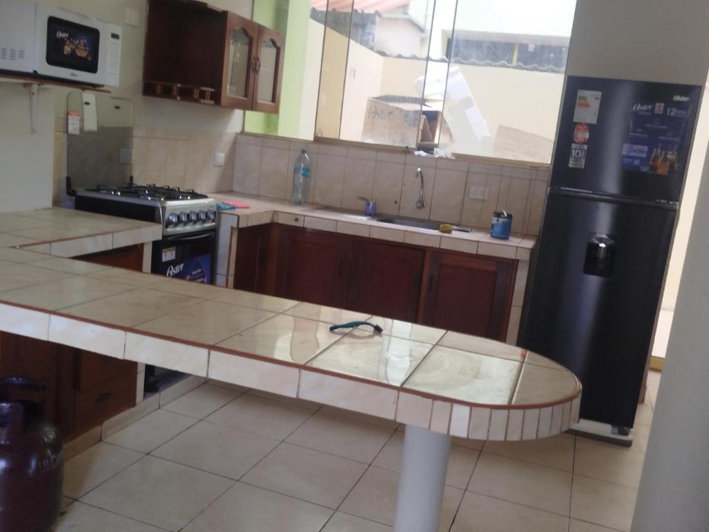 a kitchen with a counter and a black refrigerator at Casa independiente de 2 pisos con 03 cuartos in Morales