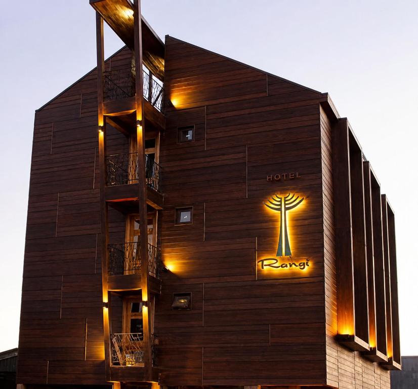 a hotel with a tree sign on the side of a building at Hotel Rangi Pucon in Pucón