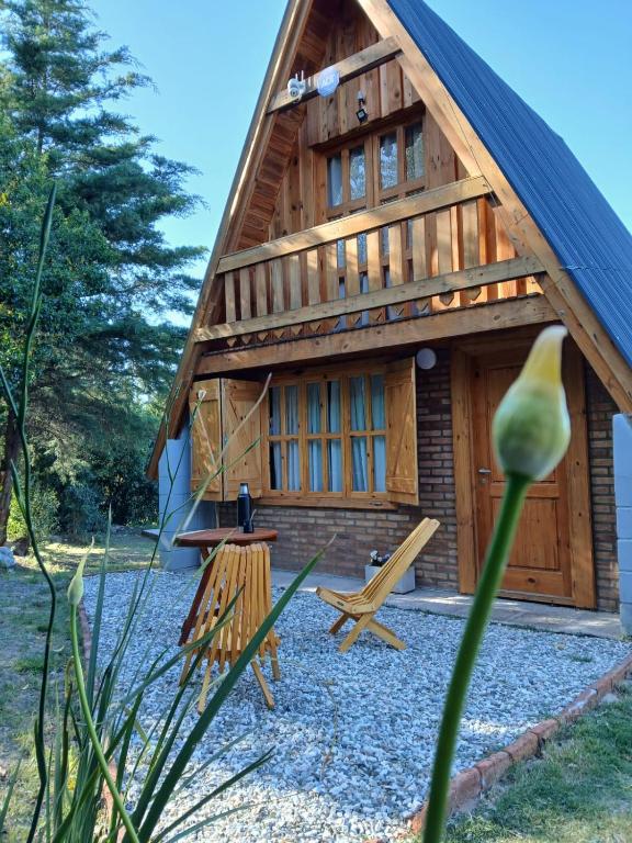 a log cabin with a bench and a table in front of it at Cabañas Damel in Villa Giardino