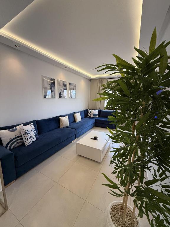 a living room with a blue couch and a plant at Cozy Flat Sea & Hills View in Marina Smir