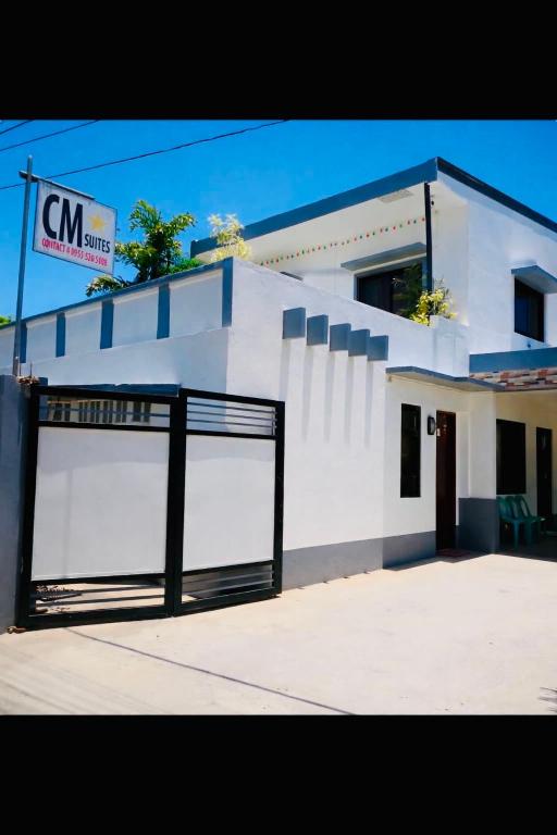 a white building with a gate in front of it at CM Star Suites - Guesthouse in Vigan