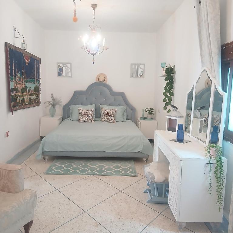 a bedroom with a bed and a table and a mirror at Sultana in Ech Chorfa