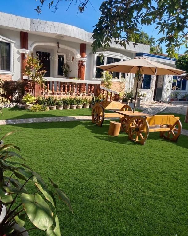 a house with a picnic table and an umbrella at 3 J'S Homestay in Carles