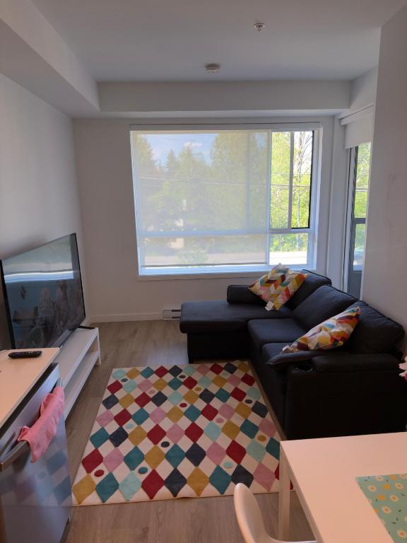 a living room with a couch and a tv at Downtown Escape in Surrey