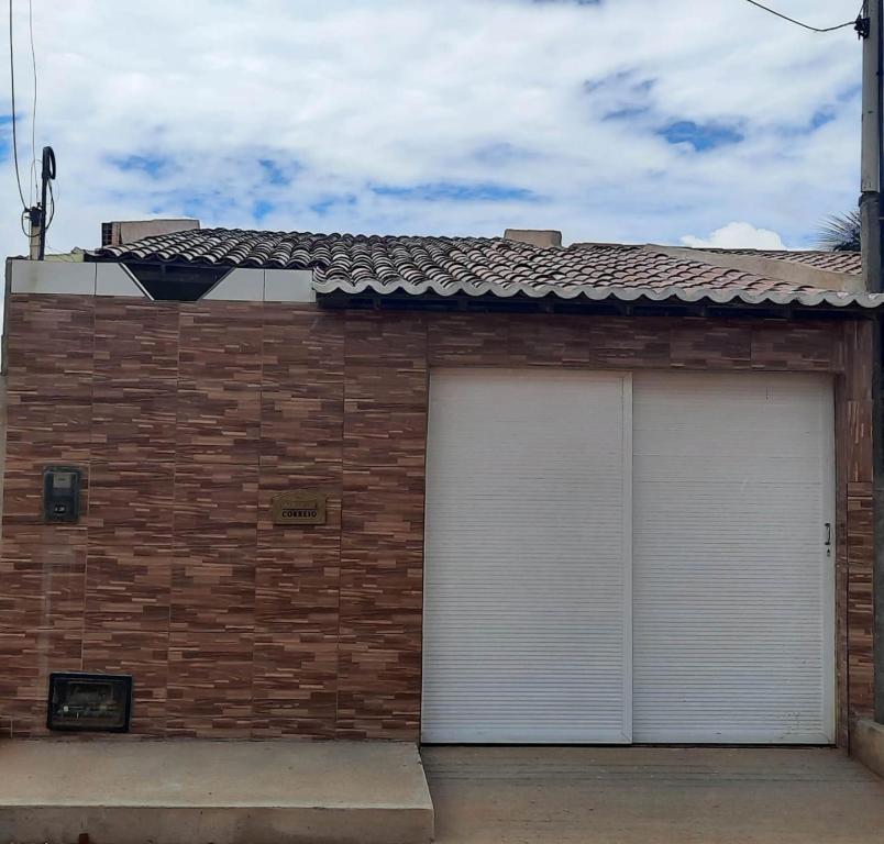 two white garage doors on a brick building at Recanto Life Beach in Camocim