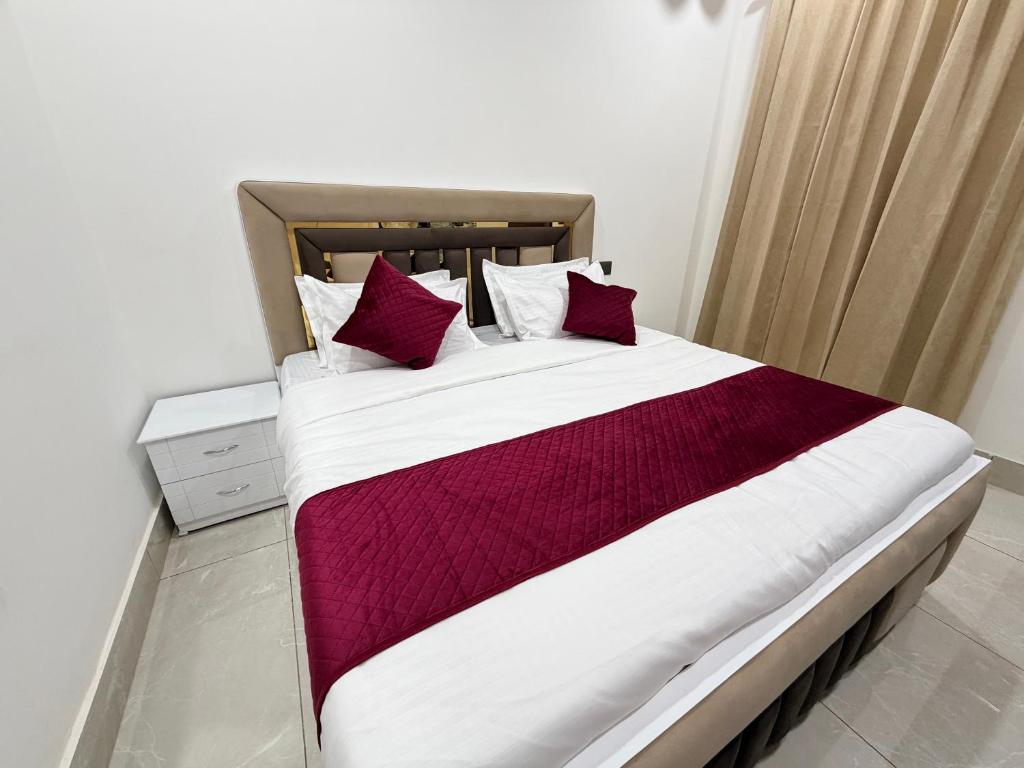 a bedroom with a large bed with red pillows at Hotel Staywell in Karnal