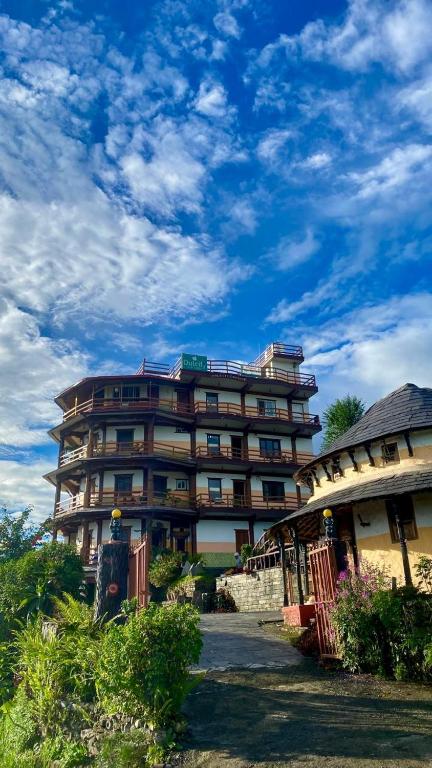 a large apartment building with a sky at Dulcify cottage sarangkot in Pokhara