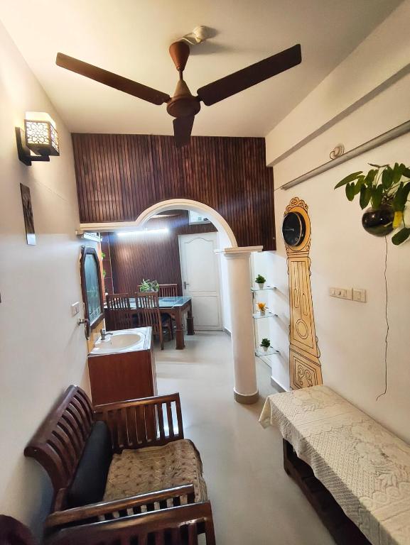 a living room with a couch and a ceiling fan at Sky Loft in Trivandrum