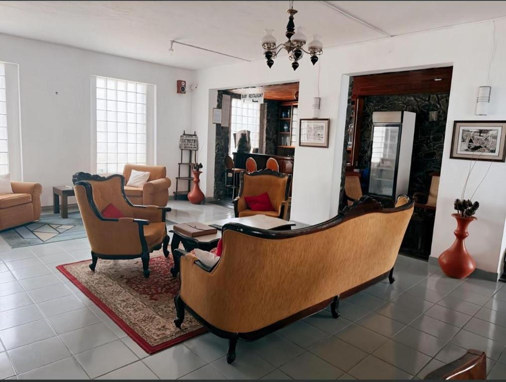 a living room with several chairs and a table at The Rock Hotel in Nuwara Eliya