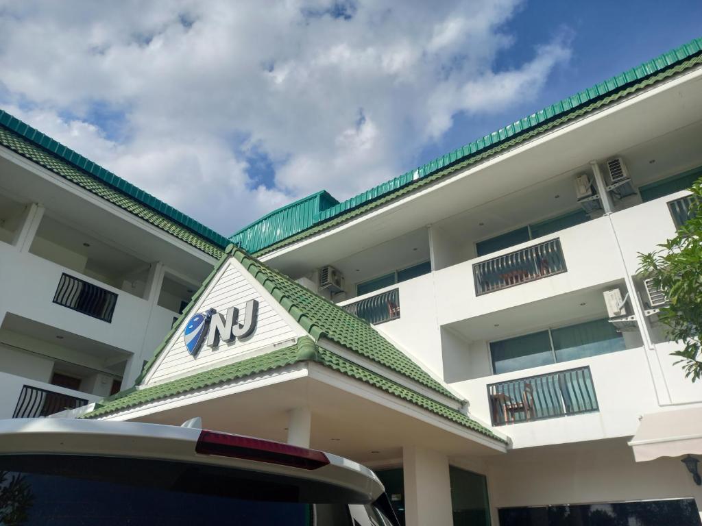 a car parked in front of a building at NJ INTHAI Hotel in Sathani Chiang Rak