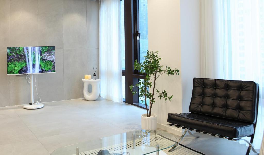 a living room with a chair and a glass table at Stay in WAVE in Ch'ŏngsap'o