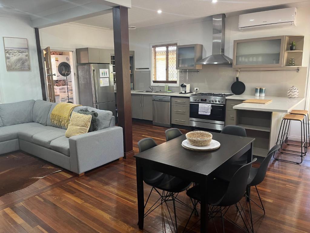 a kitchen and living room with a couch and a table at The Cooby in Spearwood