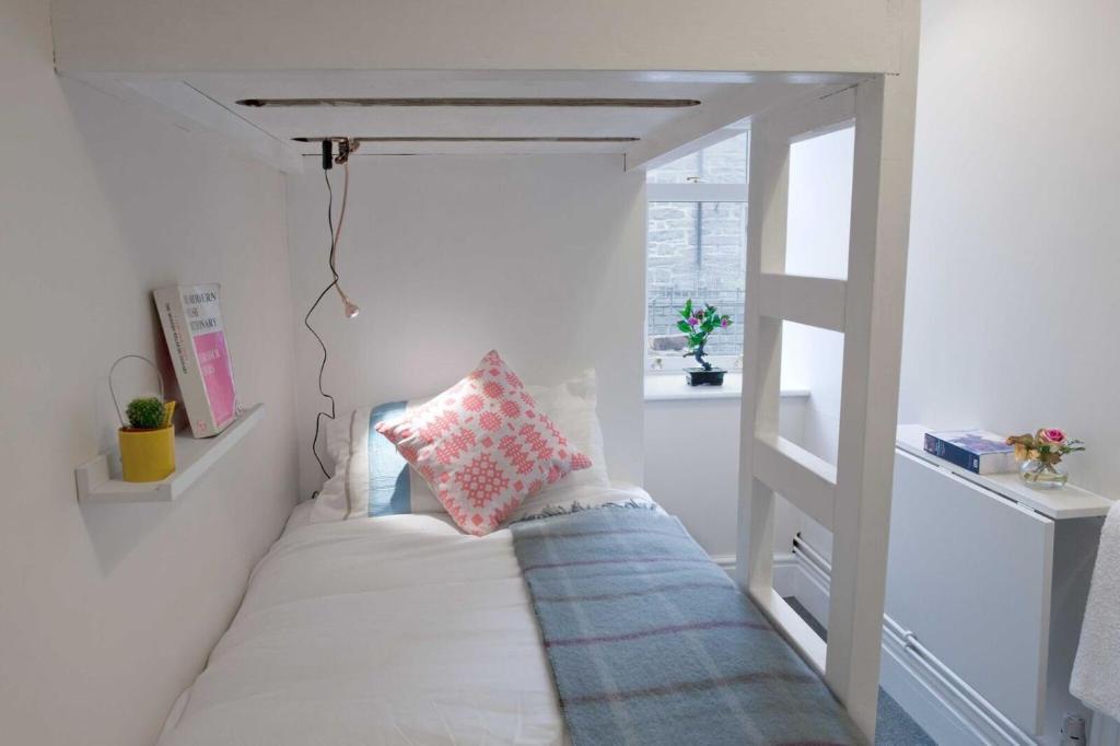 - une petite chambre avec un lit à baldaquin dans l'établissement Self Catering Cellb Ffestiniog, à Blaenau Ffestiniog