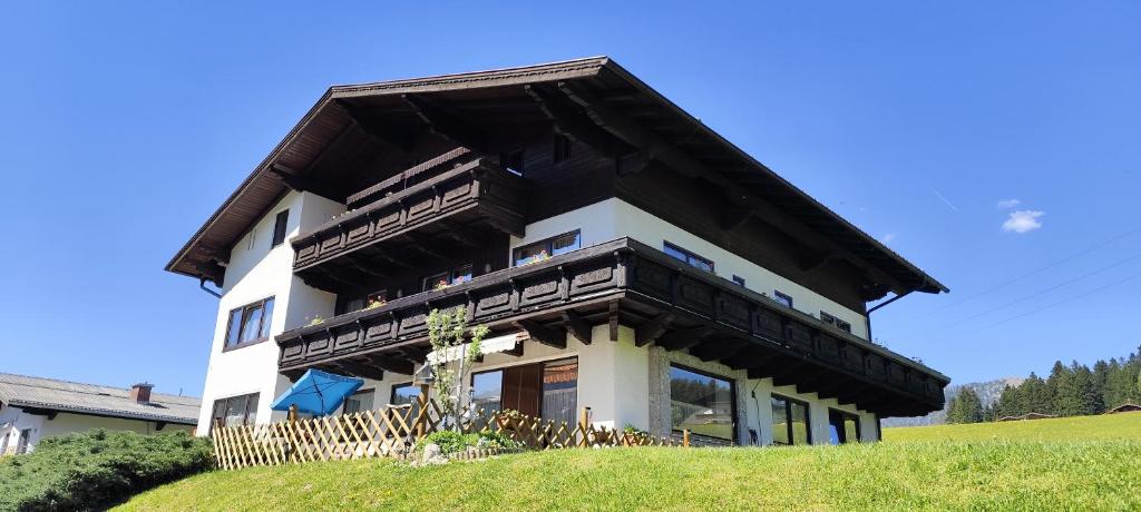 a house with a gambrel roof on a hill at Privatzimmer Pendl in Abtenau