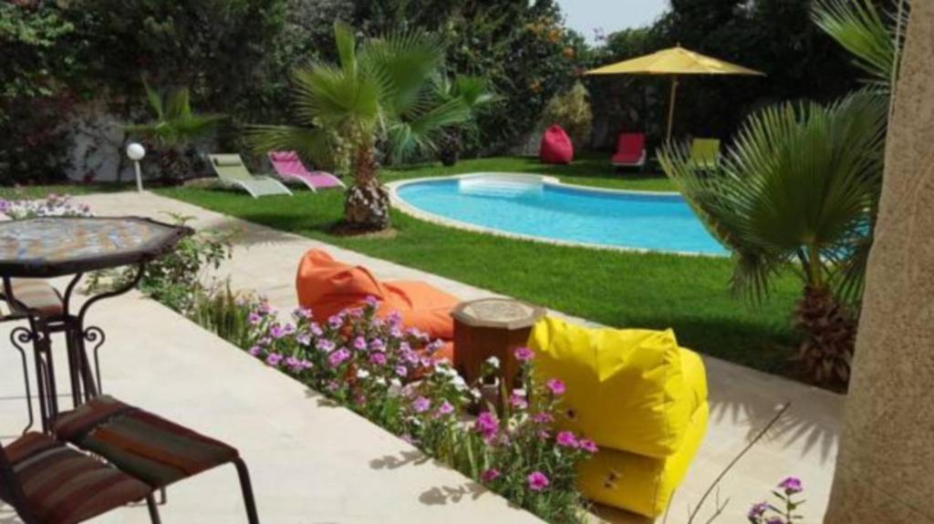 a backyard with a pool and a table and chairs at Dar Khereddine in Tunis