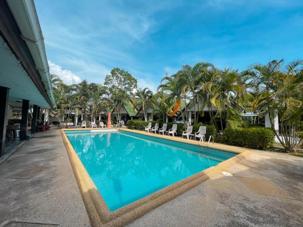 a swimming pool at a resort with chairs and trees at SouanSonBeachResort in Klaeng