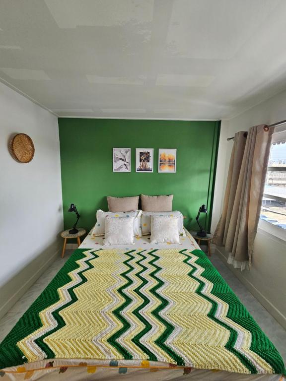 a bedroom with a large bed with a green wall at Papa house in Pak Kret