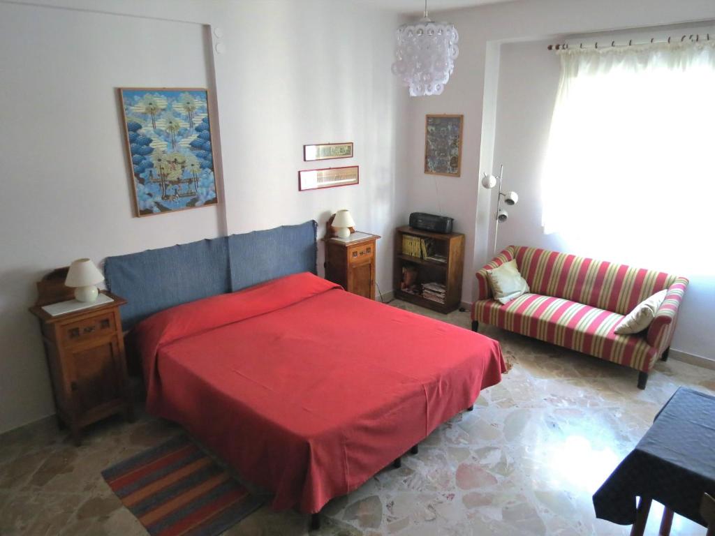 パレルモにあるAppartamento Bluのベッドルーム(赤いベッド1台、ソファ付)
