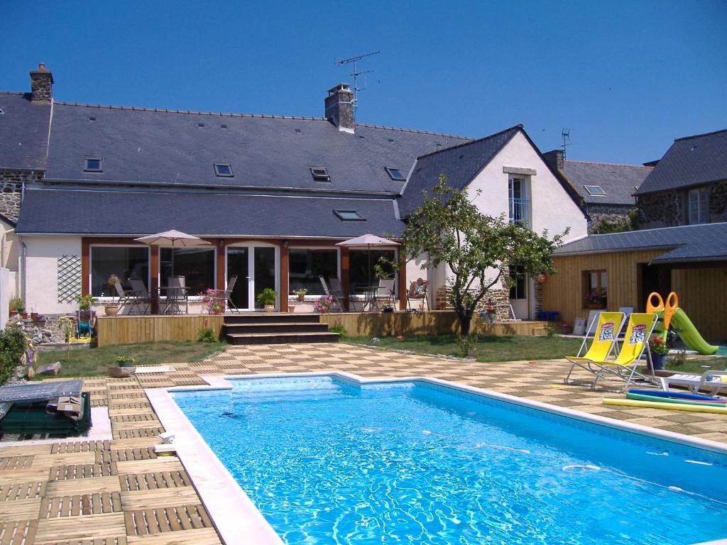 a backyard with a swimming pool and a house at La Grande Mare in Saint-Benoît-des-Ondes
