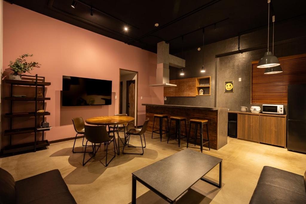 a living room with a table and a kitchen at bamboo宮古島 in Miyako-jima