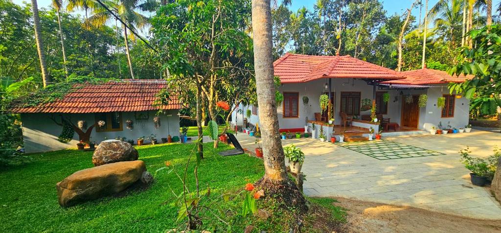 a house with a garden and a yard with a tree at Johny's Villa, Homestay, Wayanad in Pulpally