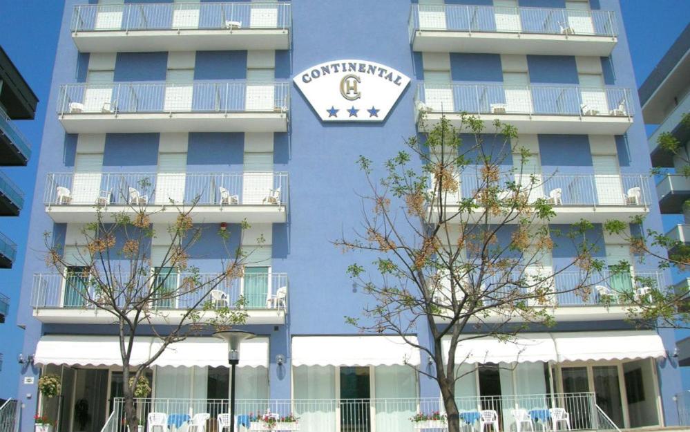 a blue building with a clock on the side of it at Hotel Continental in Pesaro