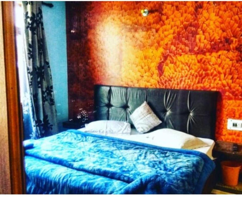 a bedroom with a bed with a black head board at Hotel Manali Villa in Manāli