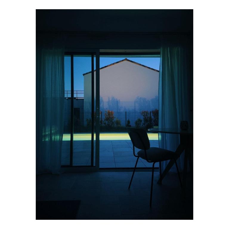 an empty room with a chair and a window at Les Joyaux d'Eliane in Le Bernard