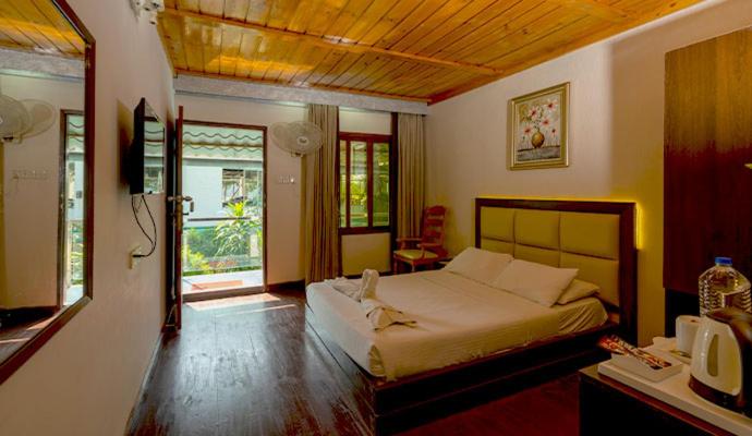 a bedroom with a bed and a television in a room at Sampan Cafe and Resort in Cox's Bazar