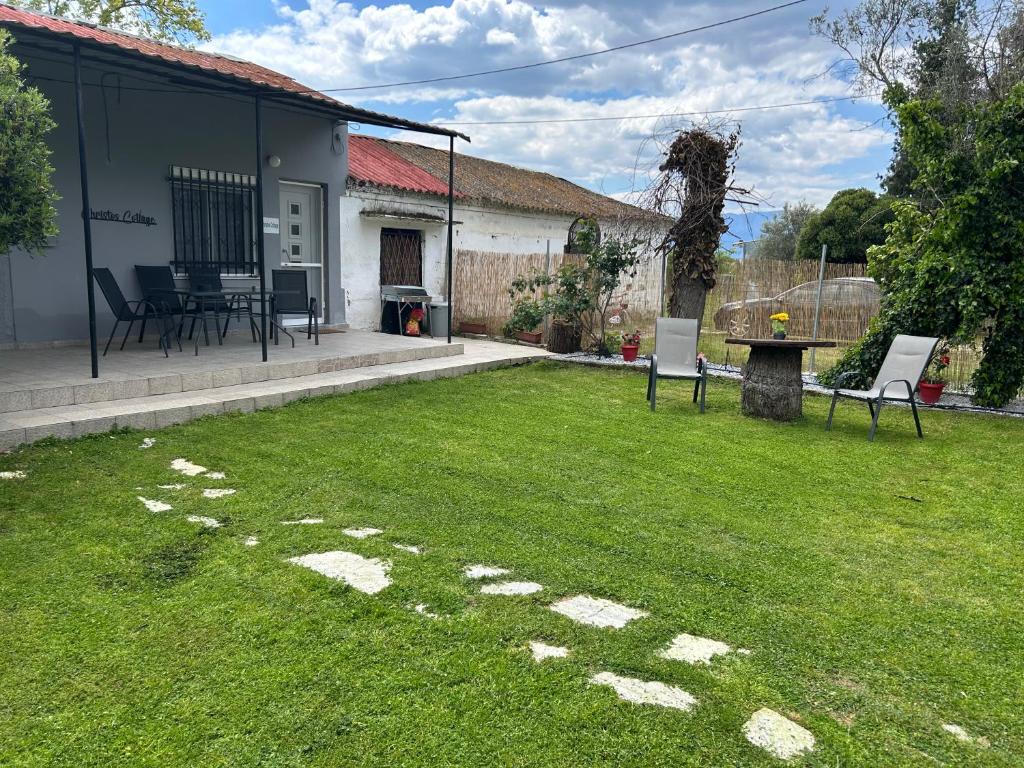 a yard with two chairs and a table in it at christos cottage! comfortable and quiet! in Keramoti