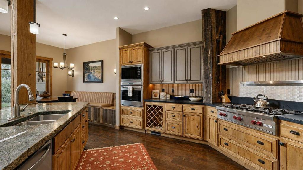 a large kitchen with wooden cabinets and a sink at BOTHR Steelhead in McCall