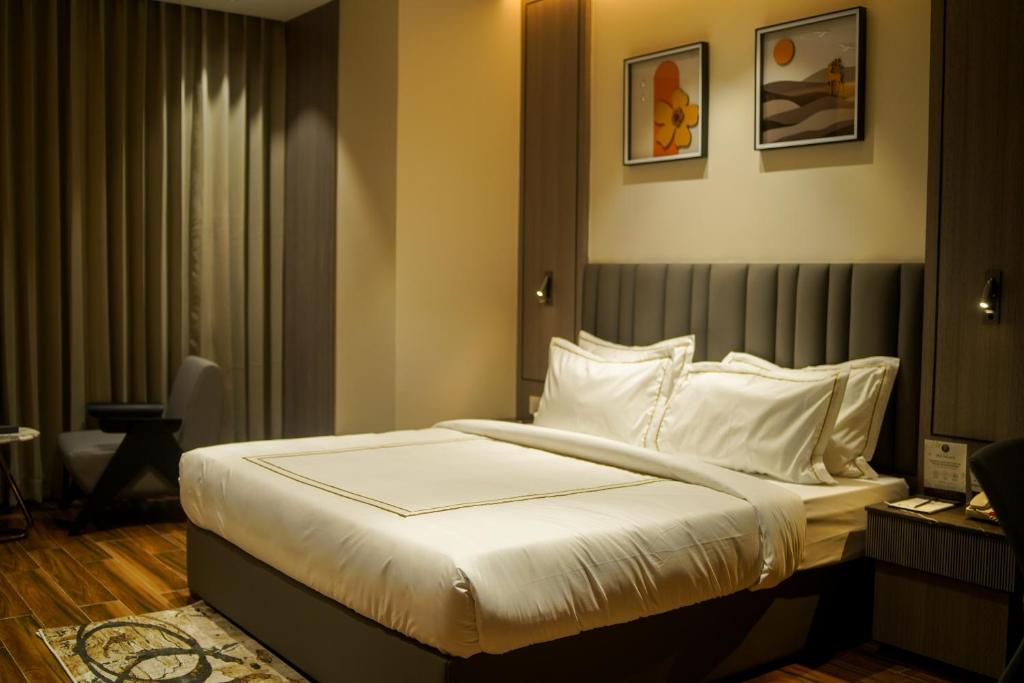 a bedroom with a bed with white sheets and pillows at Hotel PRD Palace in Saharsa