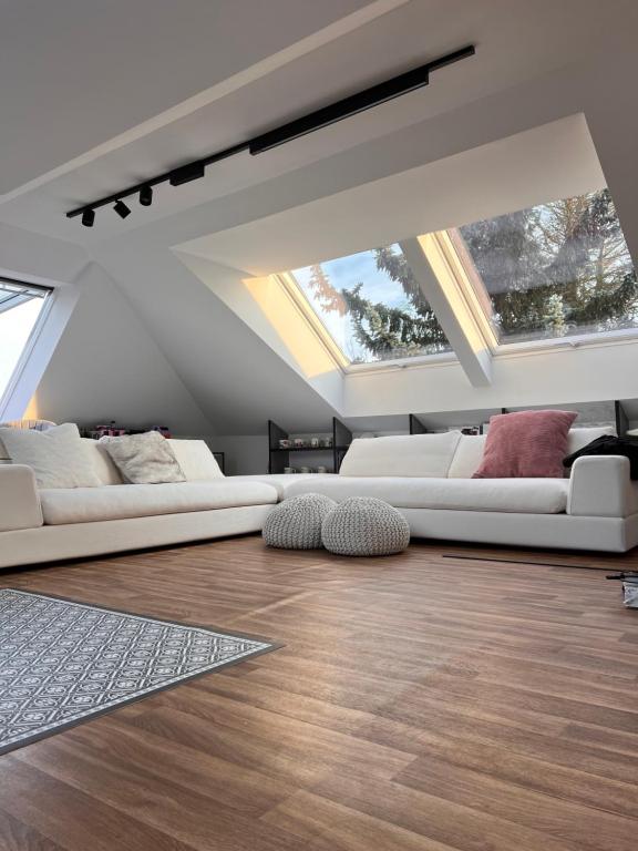two white couches in a living room with skylights at Modern Attic Loft in Weisenheim am Sand