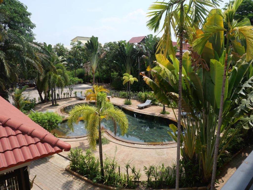 an aerial view of a resort pool with palm trees at STC Hotel School in Phumĭ Réach Born (1)