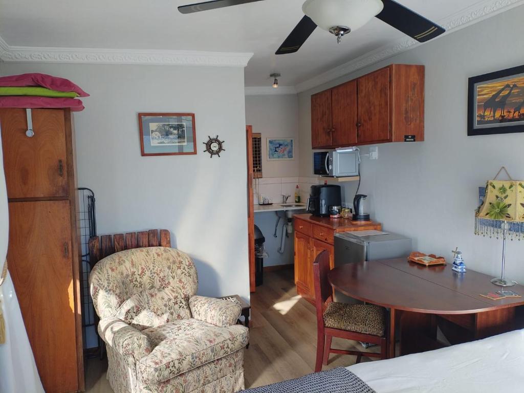 a kitchen with a table and a chair in a room at Rosa Villa in Hermanus