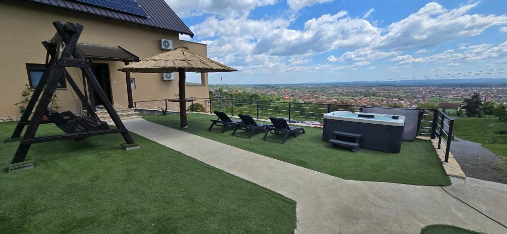 a backyard with chairs and a grill on the grass at Kuća za odmor Vista in Slavonski Brod