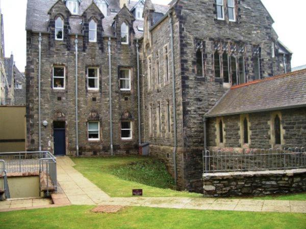 an old stone building with a gate in front of it at Moat House 1 - Ukc4887 in Fort Augustus