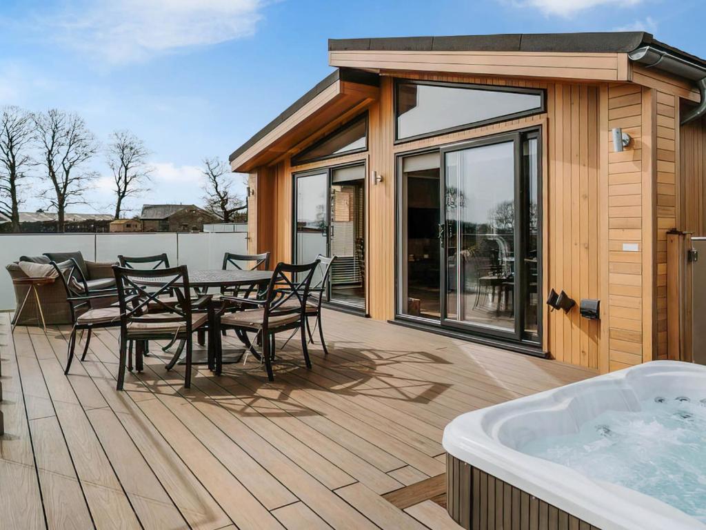 a deck with a table and chairs and a tub at Elmore - Uk51111 in Clitheroe