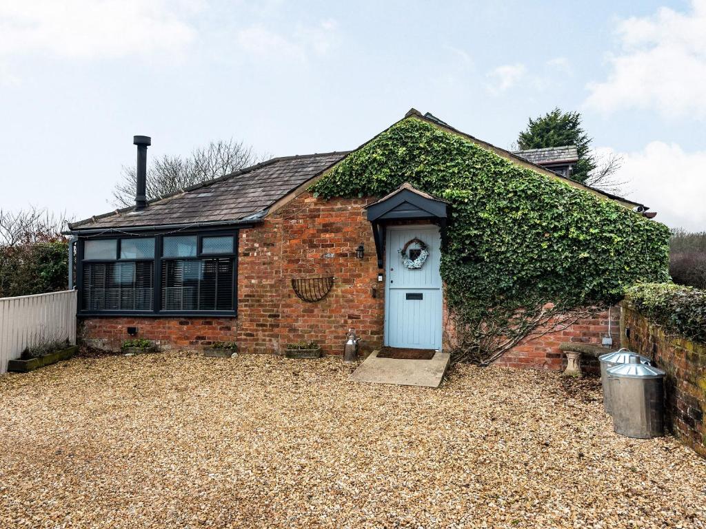 a brick house with a blue door at Greenbank Farm in Weeton