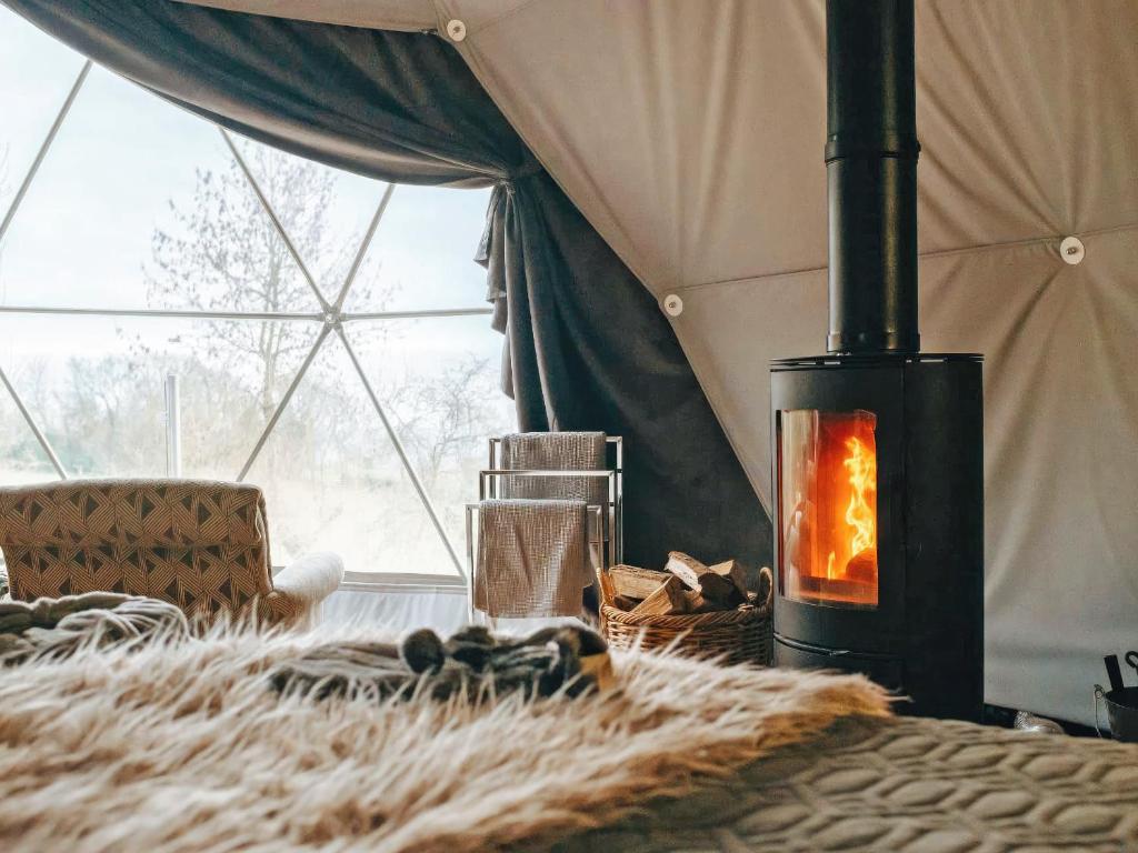 a room with a fireplace in a tent at The Star Dome - Ukc6978 in Ludlow