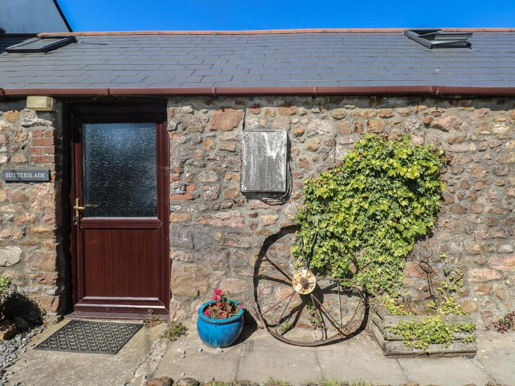 a stone house with a bike parked in front of a door at Butterslade in Swansea